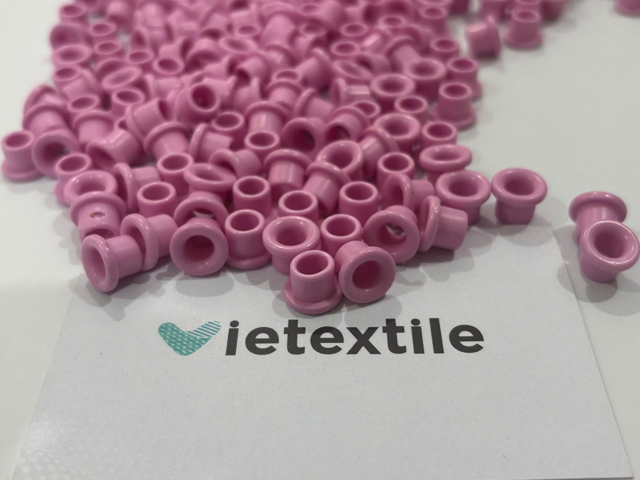 Ceramic Eyelet Risks: 7 Preventive Checks 1 A pile of pink Ceramic eyelet risks set against a white background, showcasing the material's details and glossy finish.