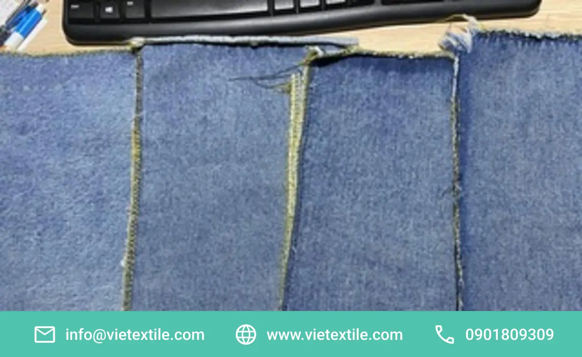 Wash Số Lượng Ít Tại TPHCM: Quy Trình Test Mẫu 1–3 Ngày 3 Các mảnh vải denim xanh với đường may và mép sờn, đặt trên bàn. Thể hiện chất lượng wash số lượng ít tại tphcm cho mẫu thử nghiệm.